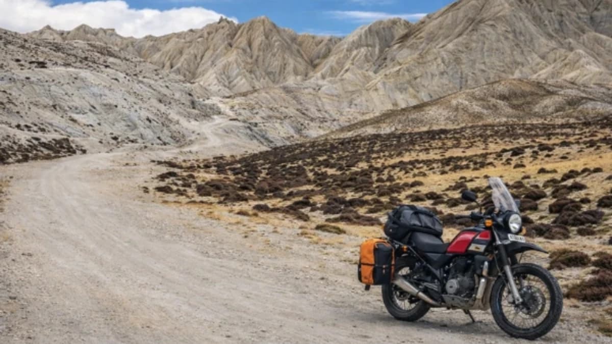 Single adventure motorbike on a remote Himalayan dirt road with dramatic rocky mountains in Nepal