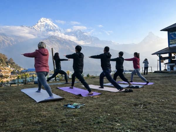 People doing outdoor yoga with mountain view.