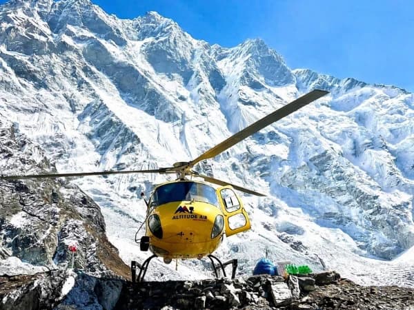 Mountain rescue and transport helicopter at a remote Himalayan landing site.