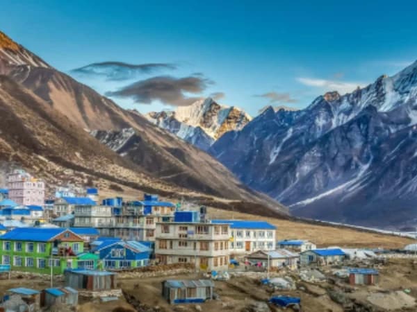 Trekkers walking on Langtang Valley trail with Himalayan peaks in background
