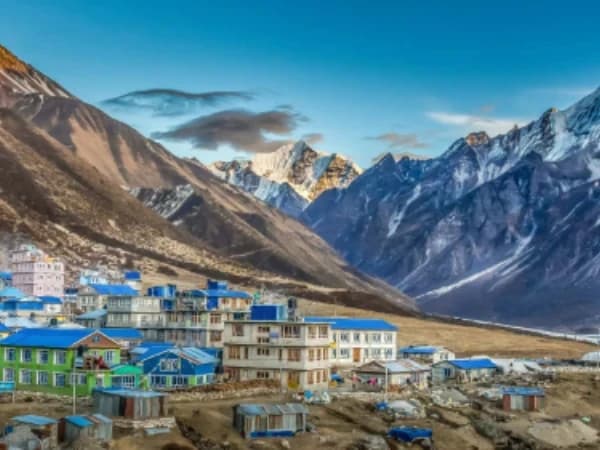 Trekkers walking on Langtang Valley trail with Himalayan peaks in background