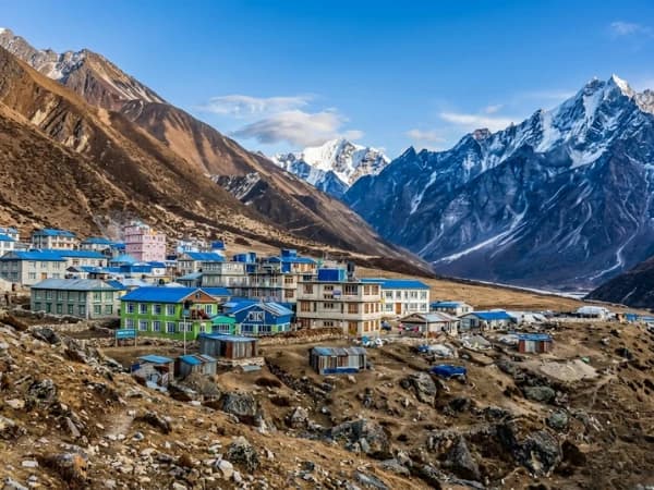 Trekkers walking on Langtang Valley trail with Himalayan peaks in background
