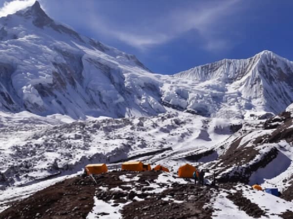 Traditional Buddhist chortens in the Manaslu Circuit Trek region with eroded cliffs and Himalayan mountains.